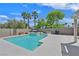 Backyard with a refreshing pool and jacuzzi surrounded by trees and a clear blue sky at 8208 Flowing Rapids Ct, Las Vegas, NV 89131