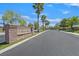 Four Winds community entrance featuring palm trees and well-maintained streetscapes offering a serene and inviting atmosphere at 8208 Flowing Rapids Ct, Las Vegas, NV 89131
