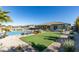 Serene backyard featuring a sparkling pool, lush artificial turf, and a covered patio for relaxed outdoor living at 8637 Home Gate Ct, Las Vegas, NV 89113