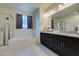 Bright bathroom featuring double sinks, granite countertops, and a large soaking tub and shower at 8637 Home Gate Ct, Las Vegas, NV 89113