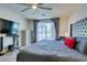 Comfortable bedroom includes a large bed with an upholstered headboard and ceiling fan at 8637 Home Gate Ct, Las Vegas, NV 89113