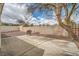 Home featuring an enclosed backyard area with stone landscaping, patio, tall walls and shade tree at 9532 Calico Garden Ave, Las Vegas, NV 89134