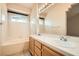The bathroom showcases a double sink vanity, a bathtub, and tiled walls complemented by arched windows at 9532 Calico Garden Ave, Las Vegas, NV 89134