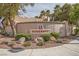 View of the 'Serenata' neighborhood entrance, with stone signage, mature trees, and manicured landscaping at 9532 Calico Garden Ave, Las Vegas, NV 89134