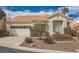 Front elevation of a charming single-story home with a tile roof, two car garage and desert landscaping at 9532 Calico Garden Ave, Las Vegas, NV 89134