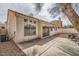 Rear of the home with a beige stucco exterior, terra cotta roof, and private backyard patio at 9532 Calico Garden Ave, Las Vegas, NV 89134