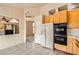 Well-lit kitchen featuring tile flooring, wood cabinetry, and a refrigerator at 9532 Calico Garden Ave, Las Vegas, NV 89134