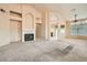 Bright, carpeted living room features a fireplace, high ceilings, and a view into the kitchen at 9532 Calico Garden Ave, Las Vegas, NV 89134