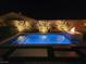 Stunning night view of backyard pool, hot tub, and fire feature, surrounded by tastefully lit landscaping and privacy walls at 9974 Petroglyph Canyon Ave, Las Vegas, NV 89166