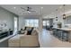 Open-concept living room with a plush sectional sofa, ceiling fan, and seamless flow to the dining area and kitchen at 9974 Petroglyph Canyon Ave, Las Vegas, NV 89166
