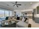 Cozy living room featuring a comfortable sectional sofa, modern lighting, and seamless access to the kitchen and dining area at 9974 Petroglyph Canyon Ave, Las Vegas, NV 89166