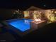 Inviting backyard pool and spa at night with a modern fire feature and subtle landscape lighting at 9974 Petroglyph Canyon Ave, Las Vegas, NV 89166