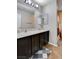 Bathroom with dual sinks, vanity lighting, tile floors, and a shower behind an ornate curtain at 11036 Mount Hunter St, Las Vegas, NV 89179