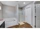 Bathroom featuring a soaking tub, glass-enclosed shower, and neutral color palette at 11036 Mount Hunter St, Las Vegas, NV 89179