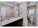 Bathroom with dual sinks, vanity lighting, and a shower behind an ornate curtain at 11036 Mount Hunter St, Las Vegas, NV 89179