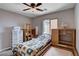 Bedroom featuring one bed, a fan, natural light, carpeted floors, and shelves at 11036 Mount Hunter St, Las Vegas, NV 89179