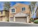 Two-story home showcasing a two-car garage with neutral-colored stucco and decorative architectural details at 11036 Mount Hunter St, Las Vegas, NV 89179