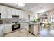 Well-lit kitchen with stainless steel appliances, modern cabinets, backsplash, and a dining area with arched windows at 2723 Seabridge Dr, Las Vegas, NV 89121