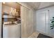 A compact laundry room with a front-loading washing machine, wire shelving, and white-painted doors at 322 Karen Ave # 4207, Las Vegas, NV 89109