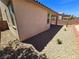 View of the side of the house and backyard with rock landscaping at 4032 Little Bay Ave, North Las Vegas, NV 89081