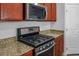 Close-up of a gas range and stainless steel microwave set in granite countertops in the kitchen at 4032 Little Bay Ave, North Las Vegas, NV 89081