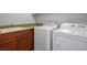 Bright laundry room with modern washer and dryer, and granite countertops over dark wood cabinetry at 4032 Little Bay Ave, North Las Vegas, NV 89081