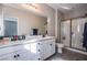 Modern primary bathroom featuring a glass shower, dual sinks, and large mirrors, providing a luxurious spa-like experience at 4533 Queens Hill St, North Las Vegas, NV 89031