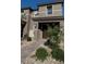 Inviting exterior of a two-story townhome with a stone pathway and desert landscaping at 4533 Queens Hill St, North Las Vegas, NV 89031