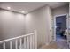Upstairs hallway with neutral paint color and a view to a bedroom at 4533 Queens Hill St, North Las Vegas, NV 89031