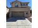 Neutral-colored two-story home featuring an attached garage and tiled roof with a paved driveway at 10393 Trailing Dalea Ave, Las Vegas, NV 89135