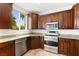 Modern kitchen featuring stainless steel appliances, granite countertops, and custom dark wood cabinets at 10393 Trailing Dalea Ave, Las Vegas, NV 89135