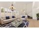 Living room with vaulted ceilings, a statement chandelier, and plantation shutters on the windows at 10393 Trailing Dalea Ave, Las Vegas, NV 89135