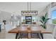 Bright dining area with a wooden table, stylish chairs, and an elegant light fixture at 10433 Mount Washington Ave, Las Vegas, NV 89166