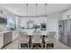 Bright kitchen featuring an island with bar seating, white cabinetry, and modern appliances at 10433 Mount Washington Ave, Las Vegas, NV 89166