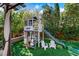 Charming backyard playhouse with slide and ladder, surrounded by lush landscaping and offering endless fun for  at 10433 Mount Washington Ave, Las Vegas, NV 89166