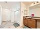 This bathroom includes a granite counter, tile floor, wood cabinets, and glass enclosed walk-in shower at 10663 Sariah Skye Ave, Las Vegas, NV 89166