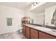 This bathroom features modern fixtures, granite counters, tile floor, and wood cabinets at 10663 Sariah Skye Ave, Las Vegas, NV 89166