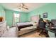 This bedroom features a bed, desk, dresser, ceiling fan, and a window providing natural light at 10663 Sariah Skye Ave, Las Vegas, NV 89166