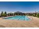 Community pool with clear blue water, ample lounge chairs, and surrounding green spaces at 10663 Sariah Skye Ave, Las Vegas, NV 89166