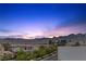 Panoramic rooftop view of a Primary-planned community with Red Rock mountains in the background at dusk at 11315 Gravitation Dr, Las Vegas, NV 89135