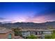 Rooftop view of a Primary-planned community with Red Rock mountains in the background at dusk at 11315 Gravitation Dr, Las Vegas, NV 89135