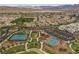 This aerial shot features the community's amenities, including tennis courts and play areas, set against a mountainous backdrop at 11315 Gravitation Dr, Las Vegas, NV 89135