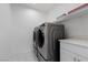 Modern laundry room with front loading washer and dryer and built in shelf and countertop at 11315 Gravitation Dr, Las Vegas, NV 89135