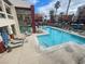 Resort-style pool with lounge chairs surrounded by lush landscaping and residential buildings at 15 E Agate Ave # 202, Las Vegas, NV 89123