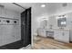 Modern bathroom featuring marble-tiled walls, a black shower curtain, and double sinks at 1660 Izabella Ave, Las Vegas, NV 89169