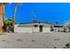 Charming home with desert landscaping and palm trees under a bright, cloudless, blue sky at 1660 Izabella Ave, Las Vegas, NV 89169