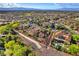 Beautiful aerial view showcasing the property's terracotta roof, manicured landscaping, and a neighborhood with city views at 1795 Anelli Ct, Henderson, NV 89012