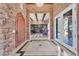 Grand foyer featuring stone walls, marble flooring, and wood trimmed arched doorway and entry at 1795 Anelli Ct, Henderson, NV 89012
