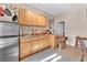 Functional kitchen with wood cabinetry, a stainless steel refrigerator, and a breakfast bar at 1795 Anelli Ct, Henderson, NV 89012