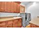 Functional laundry room equipped with modern washer and dryer units, wooden cabinets and a sink at 1795 Anelli Ct, Henderson, NV 89012